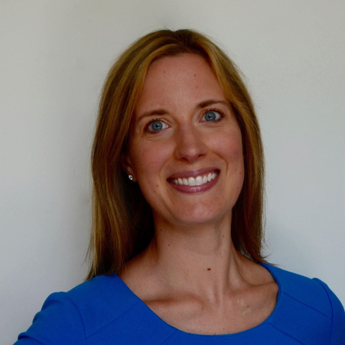 A person in a suit smilingDescription automatically generated