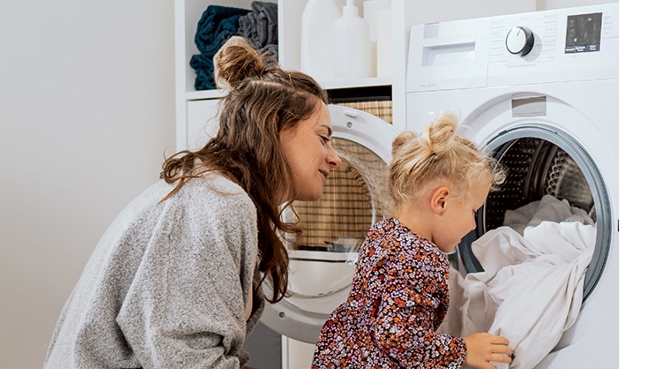 Mother and daughter doing laundry at home 