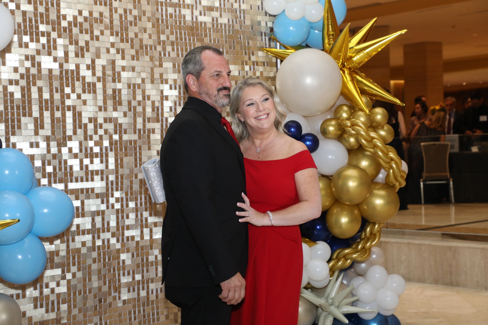 Guests Pose In Front of Backdrop
