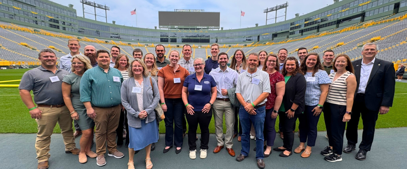 A group of individuals pose at Lambeau Field