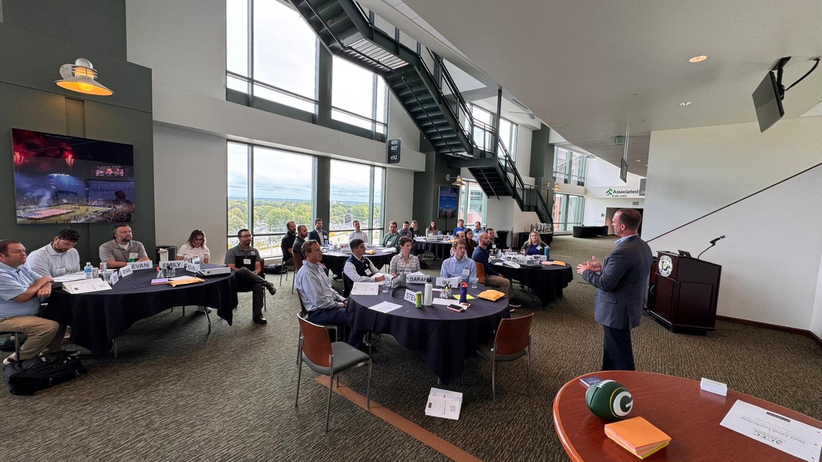Members of the ACEC Wisconsin Leadership Institute Class of 2027 pose beside the field at Lambeau Field.