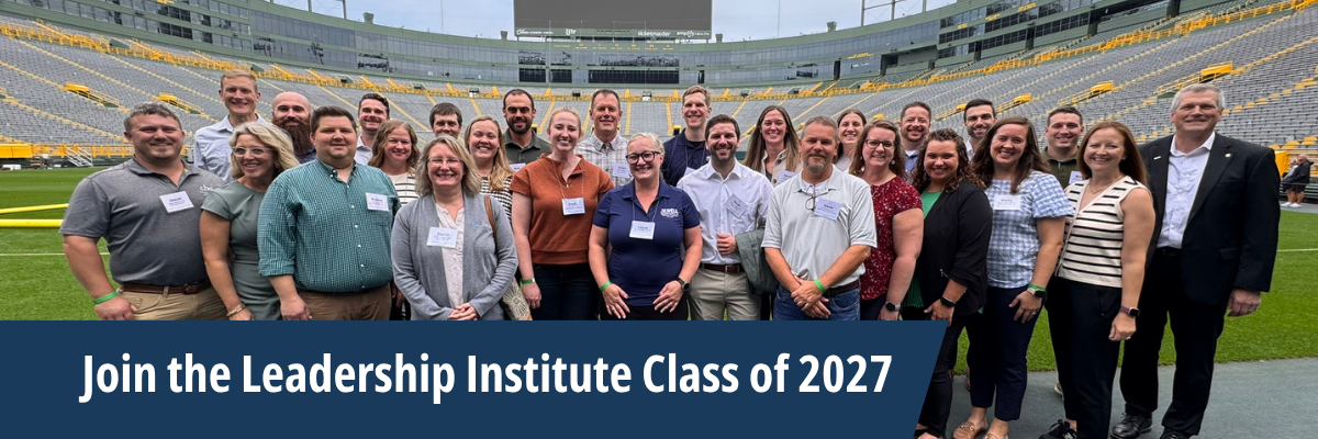 A group of people stand in front of Lambeau Field as part of the Leadership Institute class.