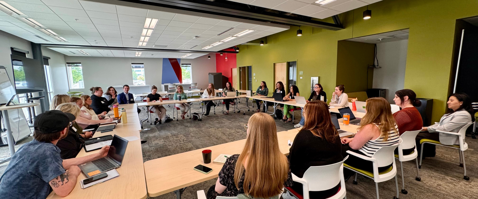 Group of people discussing AI around a hollow square table.