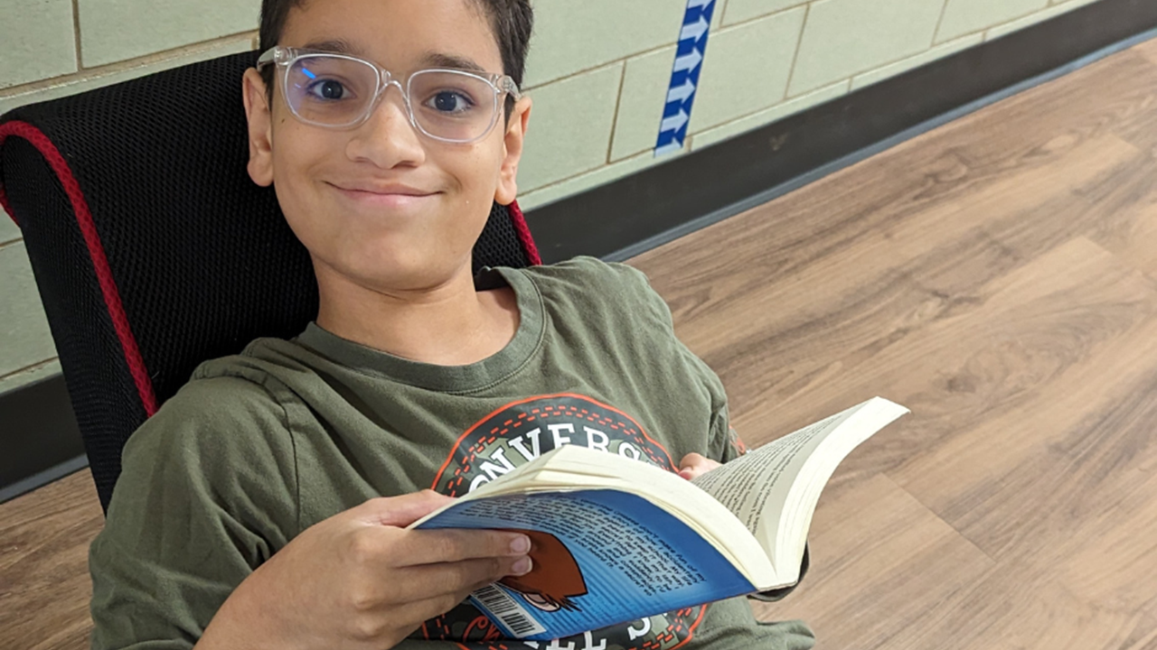 Lower School student enjoying his chapter book while using multi-modal seating. 