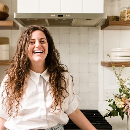 A person smiling in a kitchenAI-generated content may be incorrect.