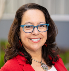 A person wearing blue glasses and a red jacketAI-generated content may be incorrect.