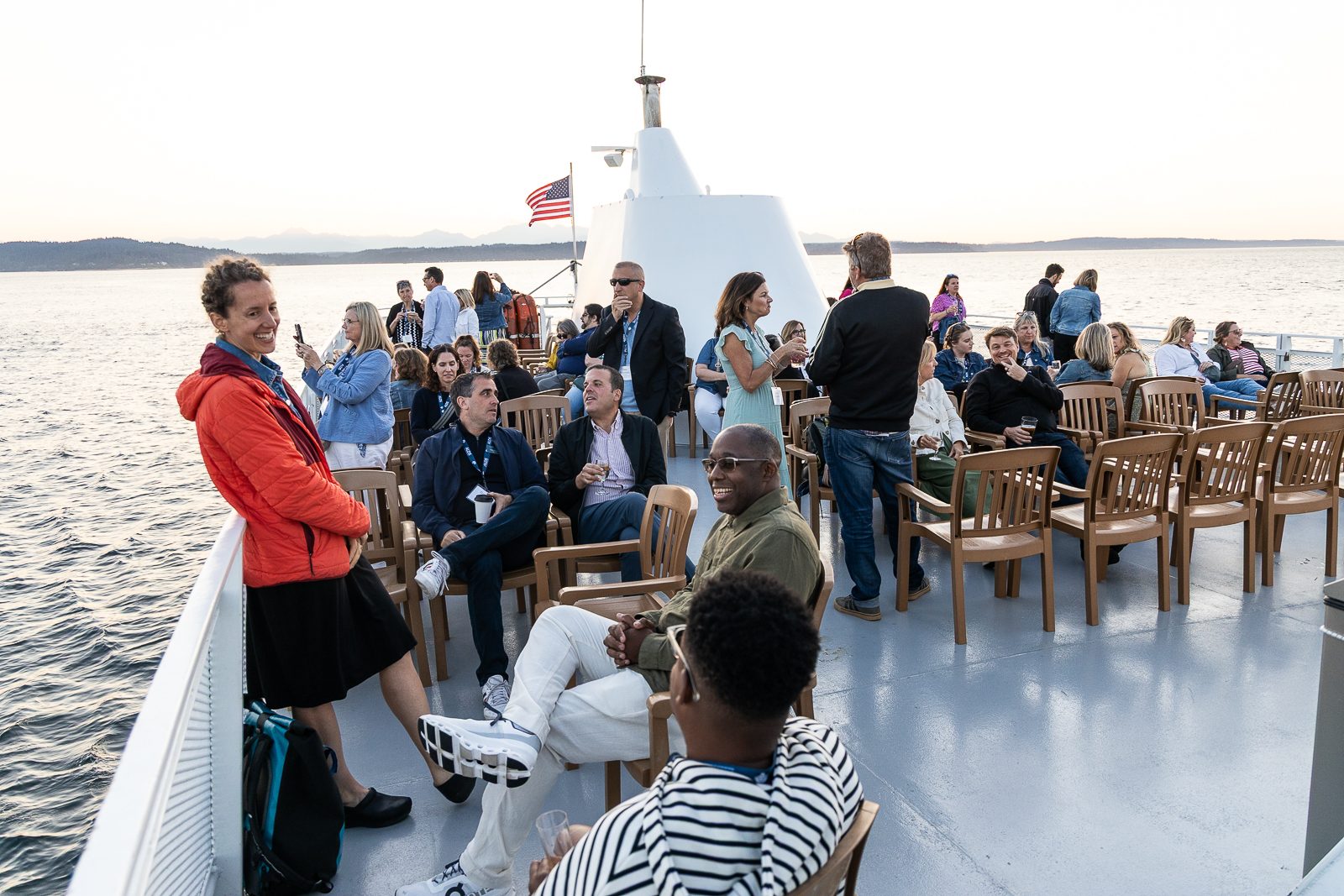 Attendees relaxing and interacting aboard a boat at sunset