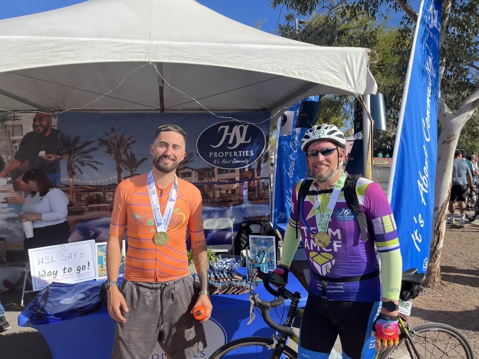 2 cyclists posing for a picture smiling