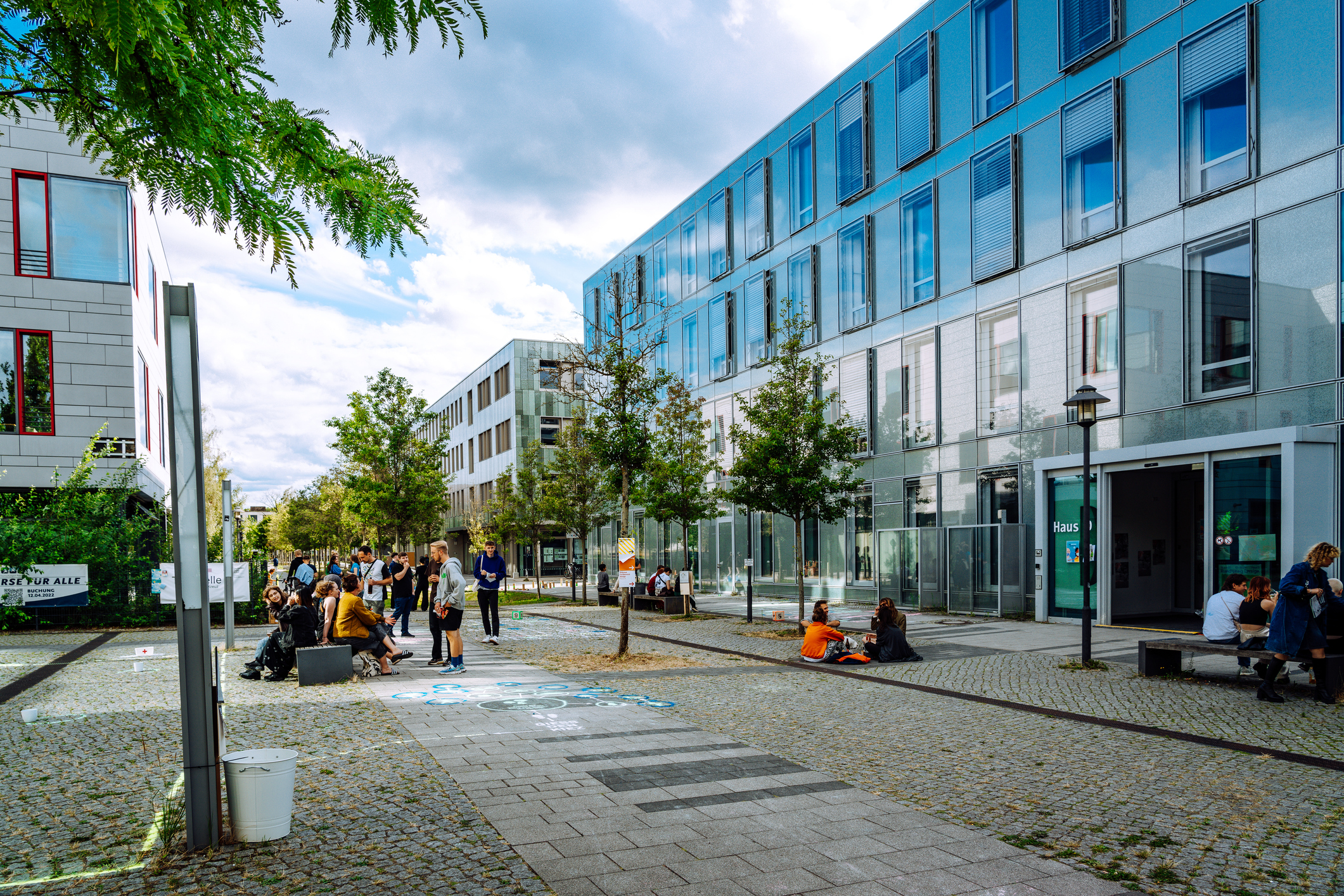 Students gathered on a plaza outside modern campus buildings