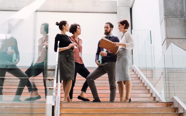 Professional conversing atop modern staircase