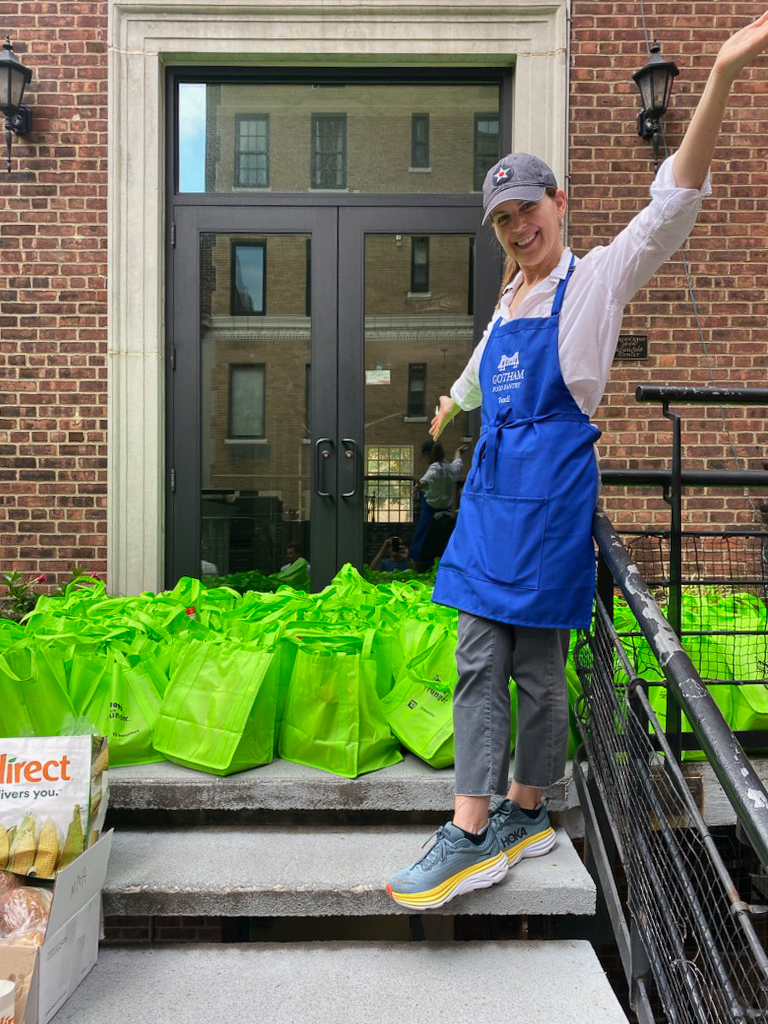 Person in front of green bags smiling