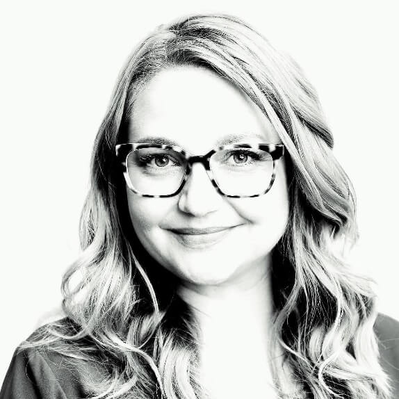 A person wearing glasses and smilingAI-generated content may be incorrect.