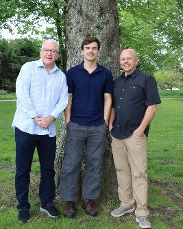 A group of men standing next to a treeAI-generated content may be incorrect.