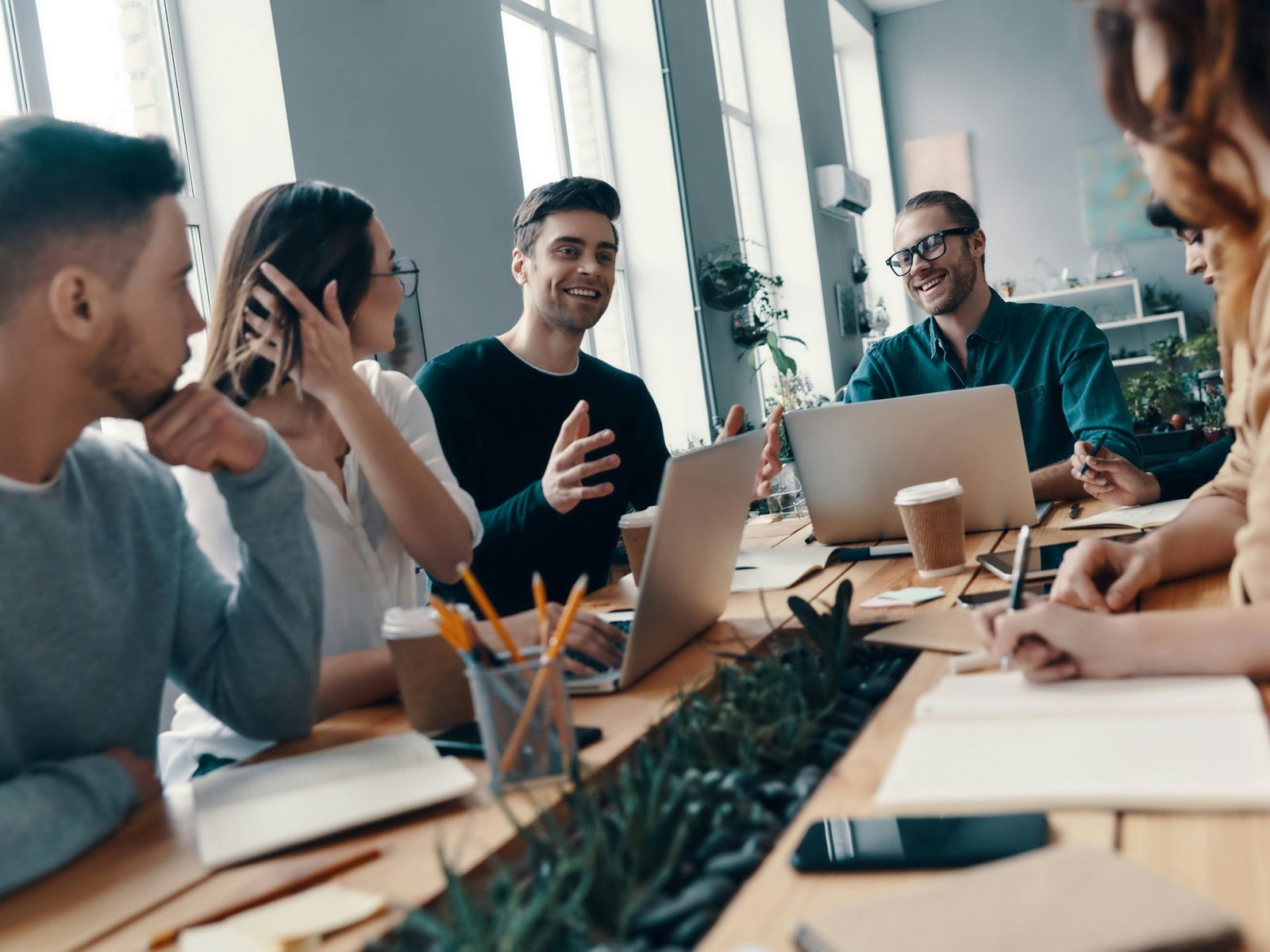 A team talks around a long work table