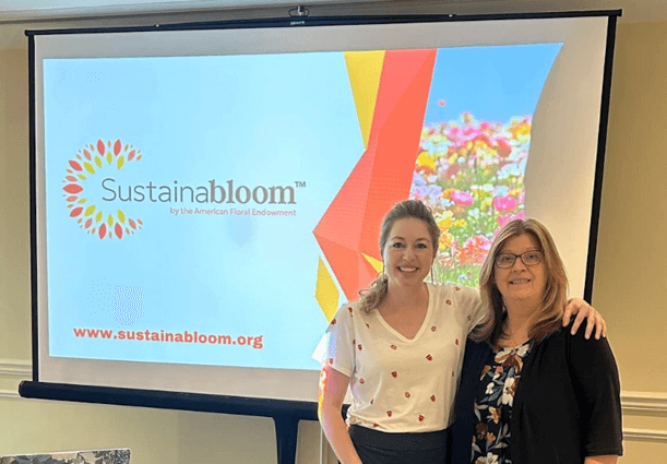 Two women standing in front of a large screenAI-generated content may be incorrect.