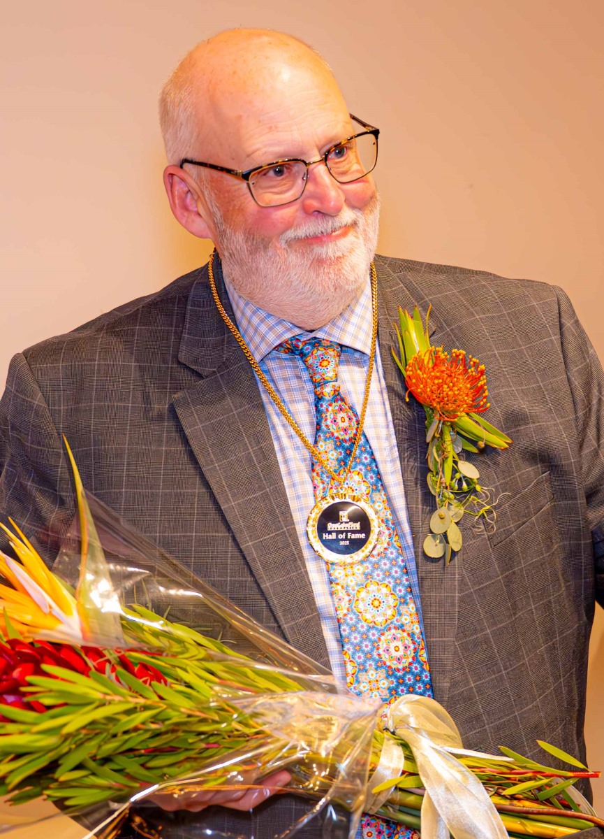 A person in a suit holding flowersAI-generated content may be incorrect.