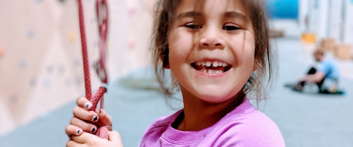 Young girl smiling at climbing gym