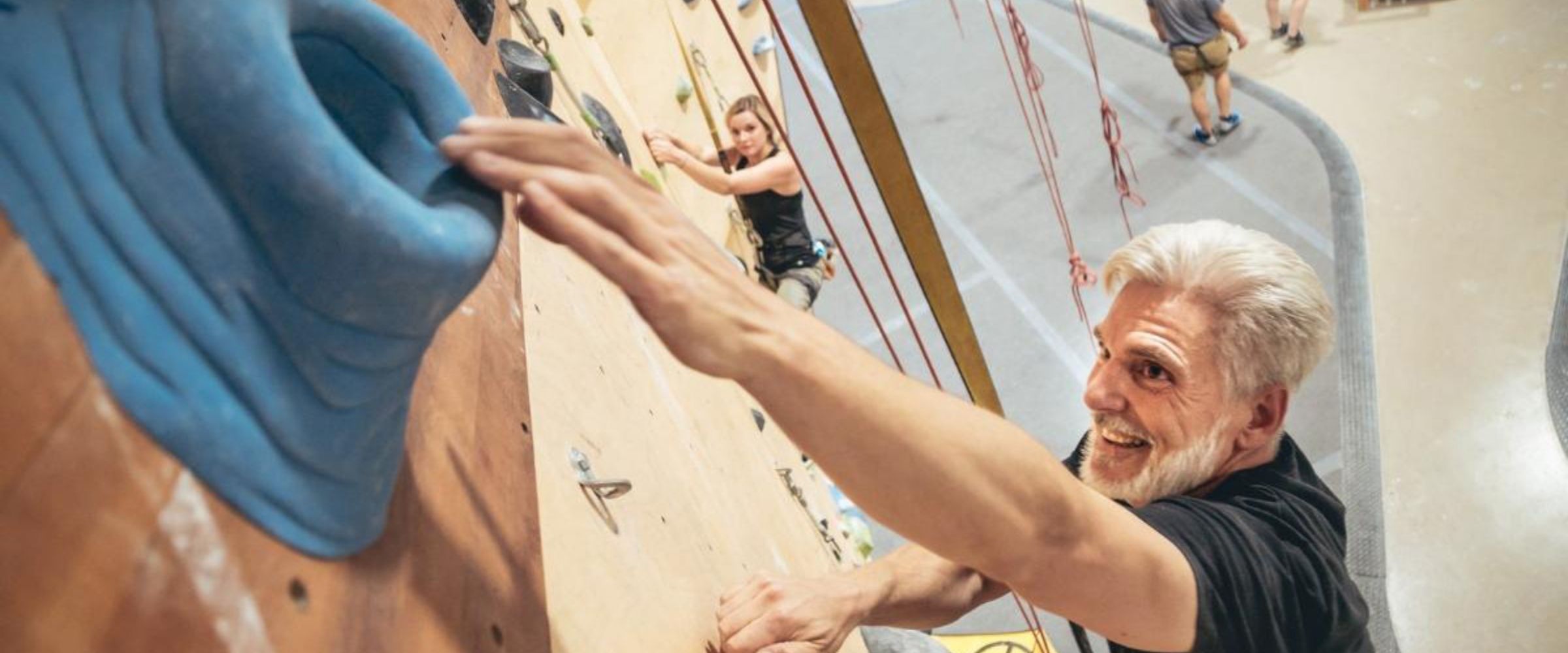 Elder man indoor rock climbing