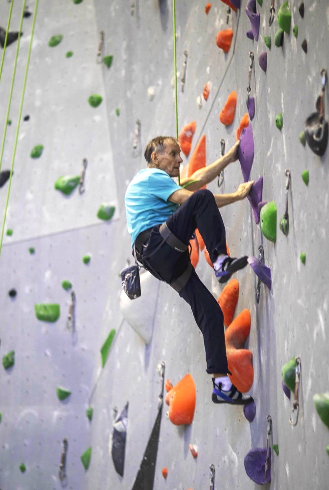 A person participating in an indoor climbing session with UpENDing Parkinson's