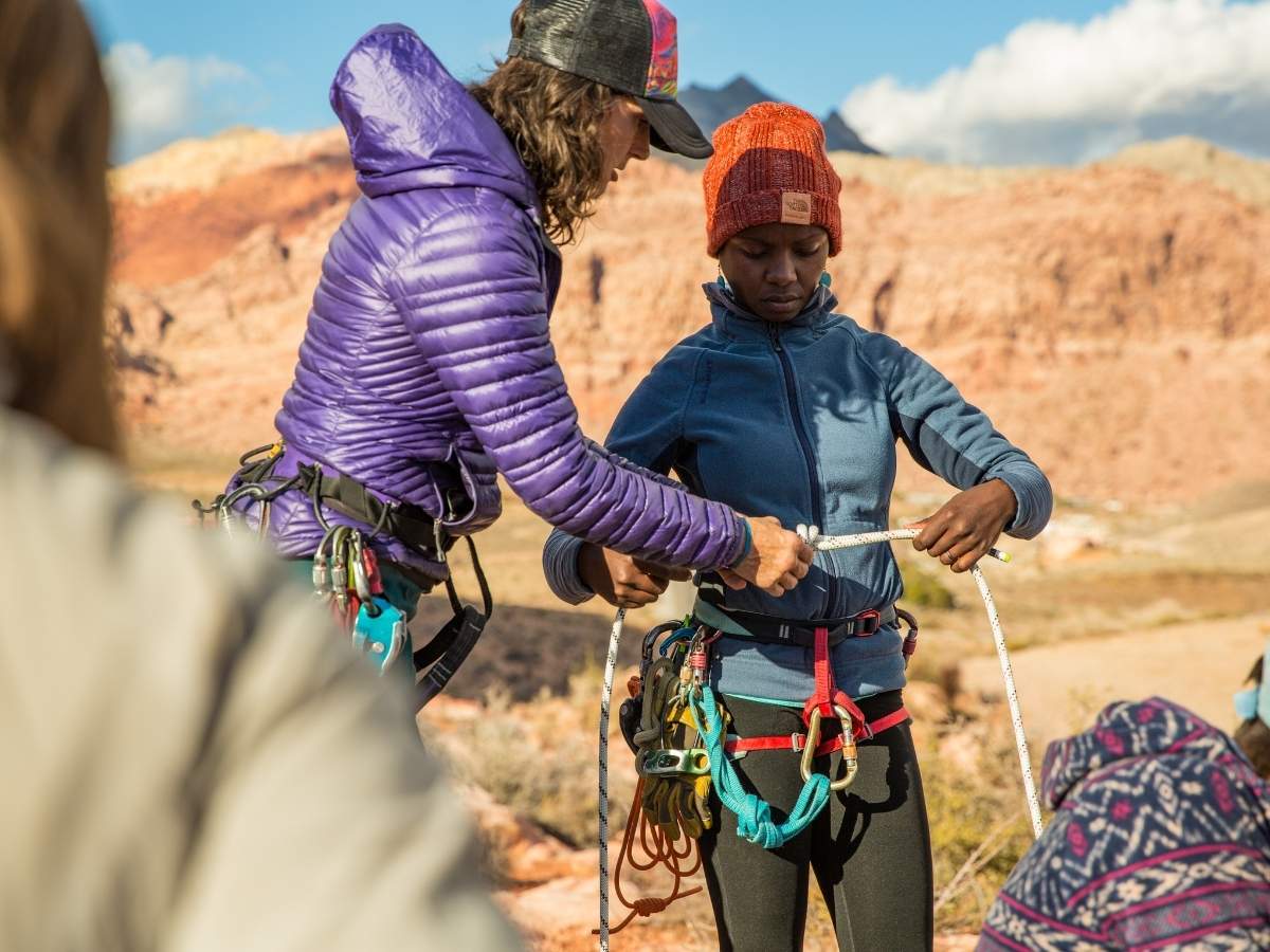 Young rock climber being taught outdoors