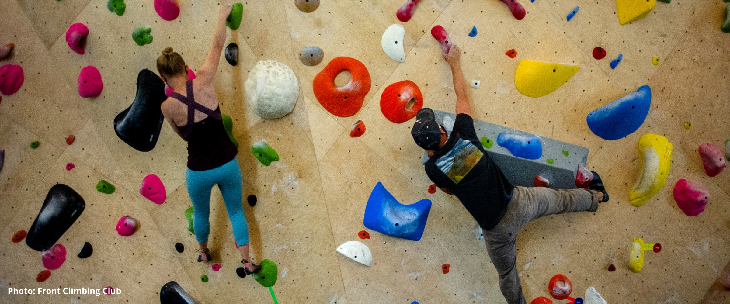 Climbers traversing a bouldering wall