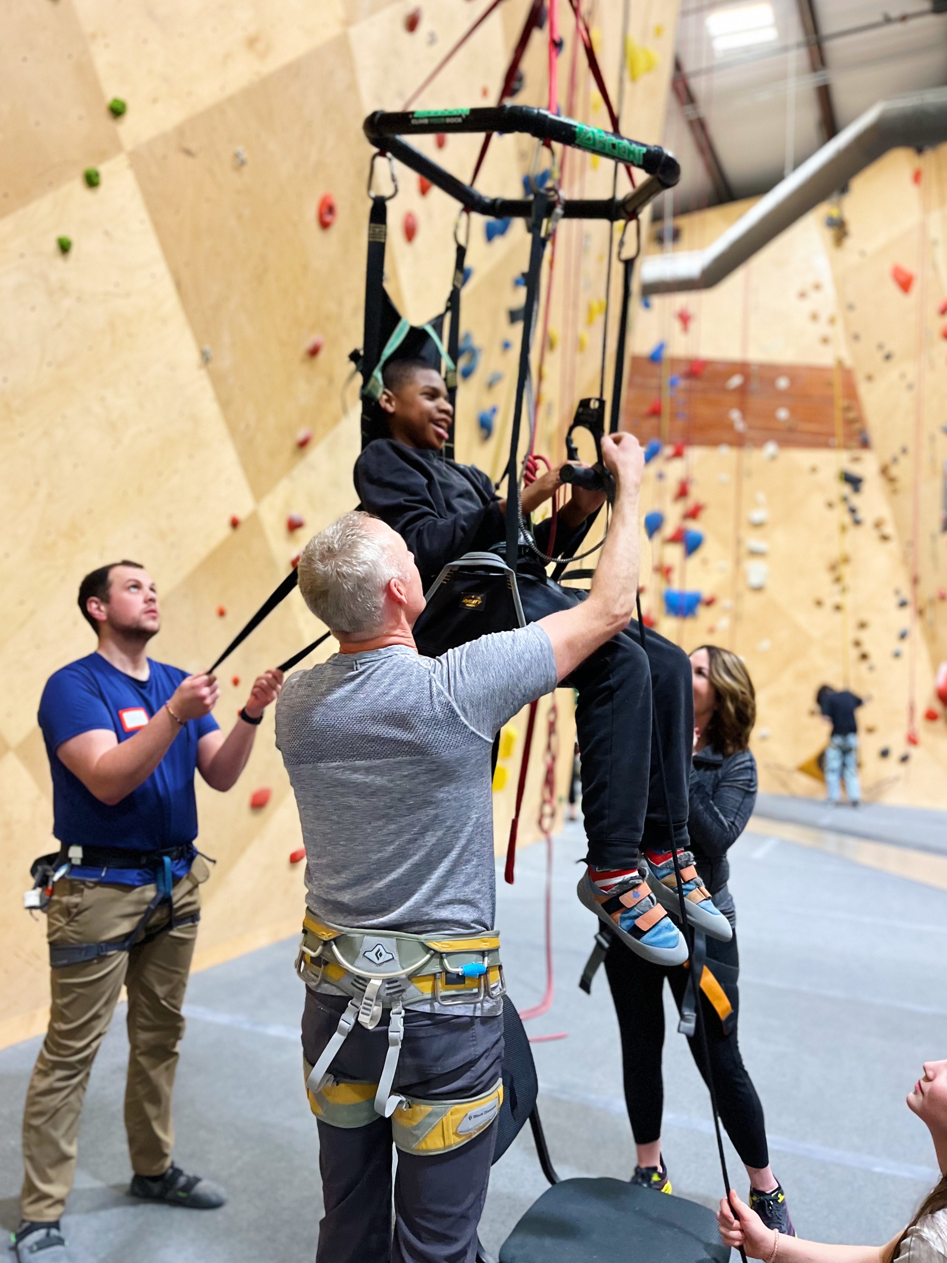 Person with disability climbing inside indoor climbing gym