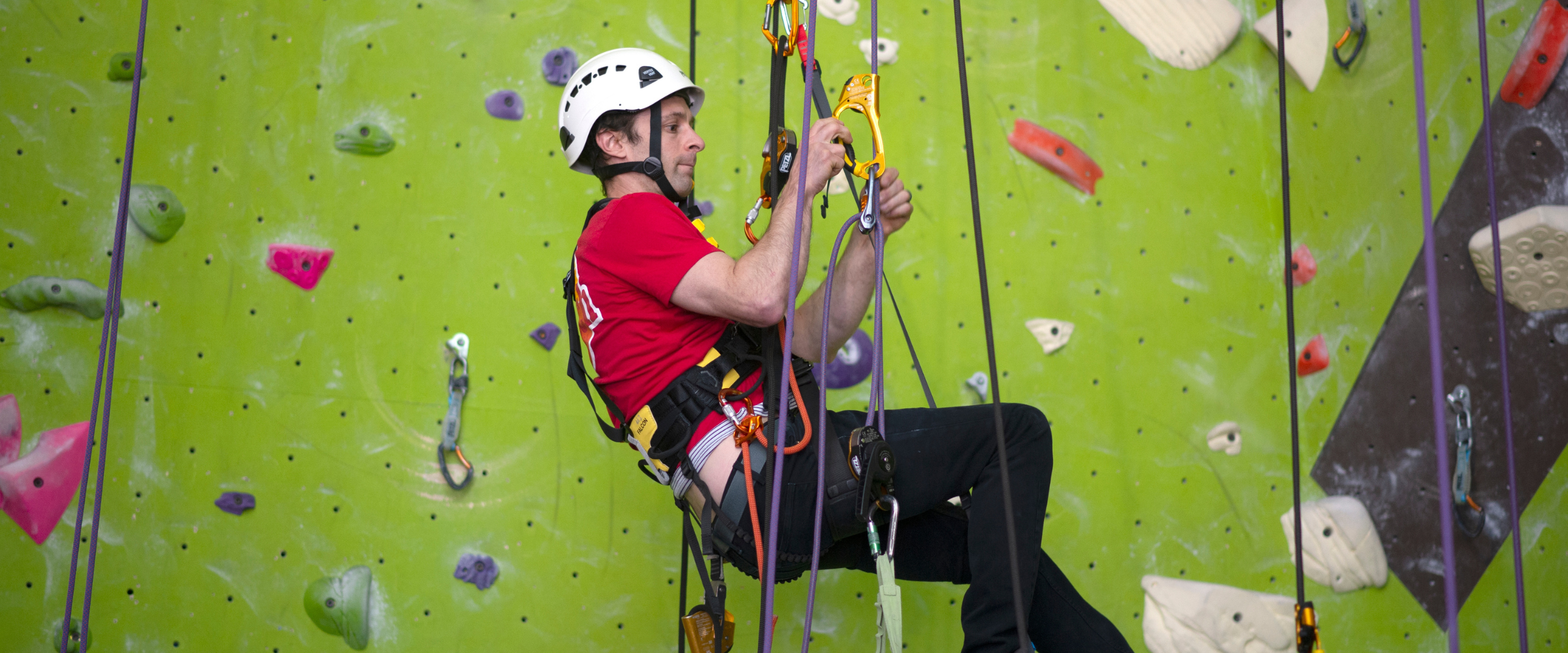 A person completing a Climbing Wall Association Certification Course.