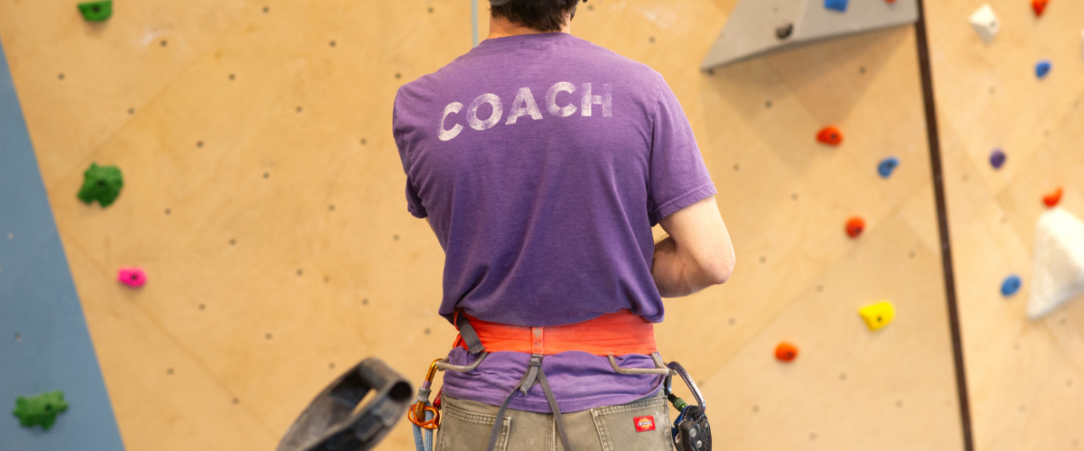 Person in indoor climbing gym belaying