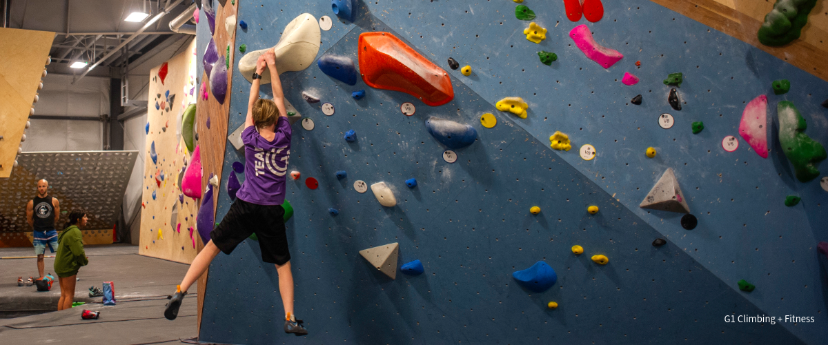 A kid climbs inside an indoor climbing gym