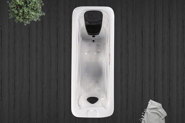 A white bathtub with a black handleDescription automatically generated