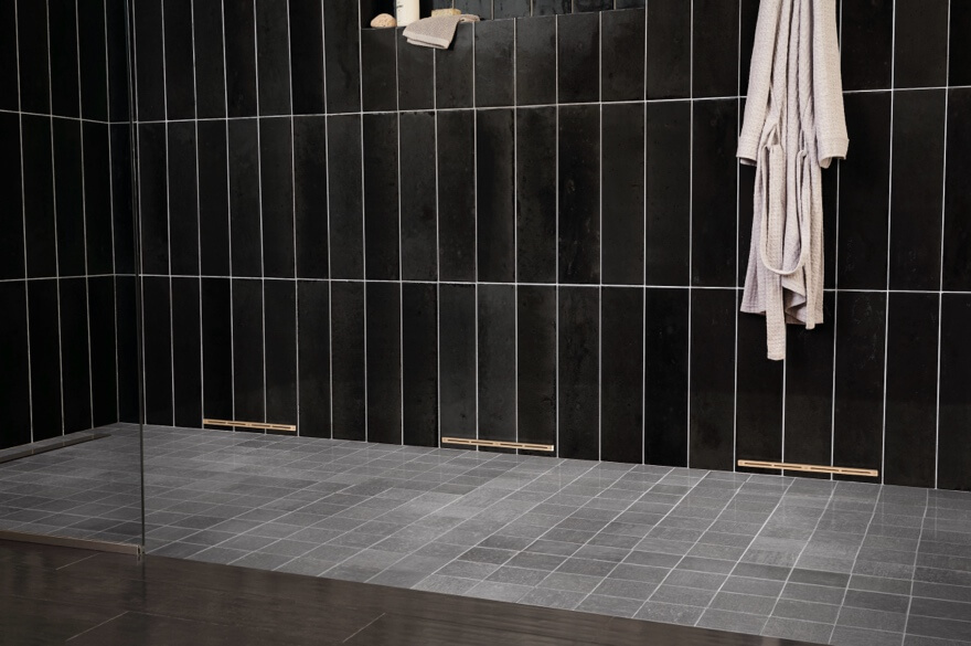 A black tile wall with a towel on itAI-generated content may be incorrect.