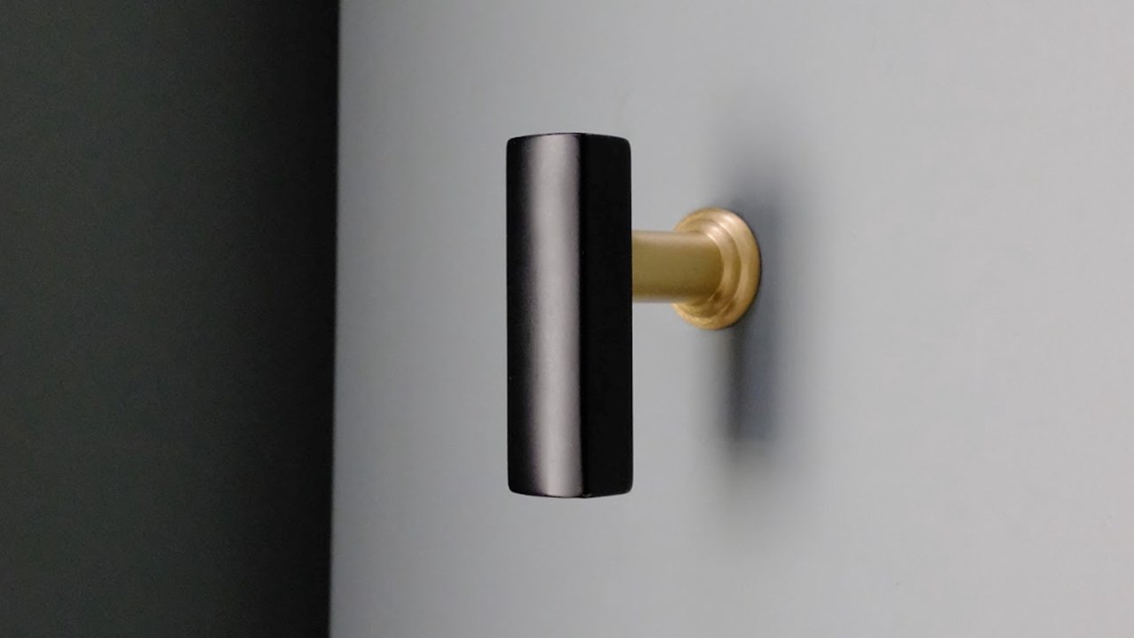 Hapny Mod T-Knob in Black and Satin Brass installed on a blue bathroom drawer