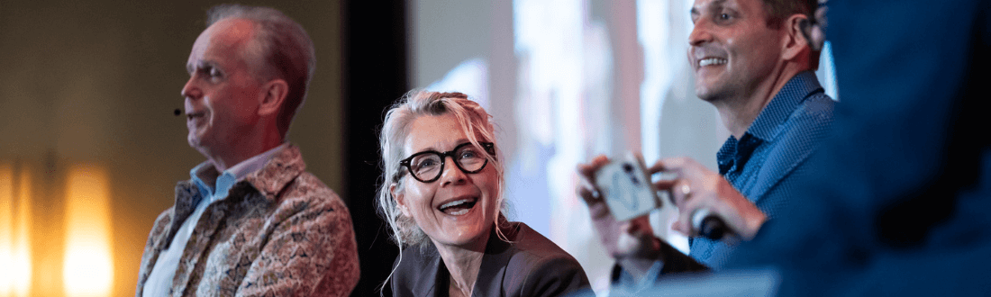 4 people on stage at a GALA conference, talking and smiling
