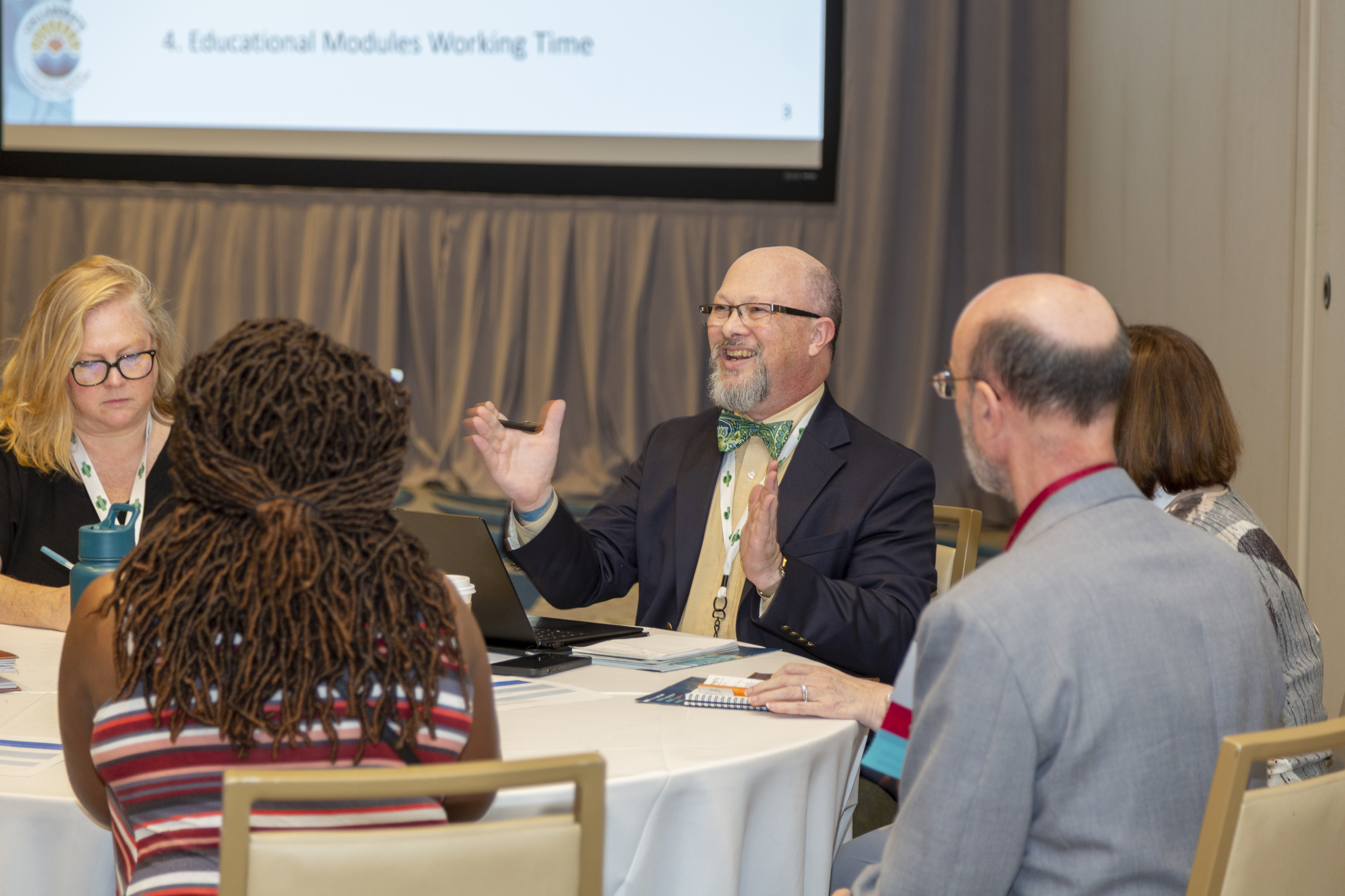 The Forum attendees at a round table talking and smiling.