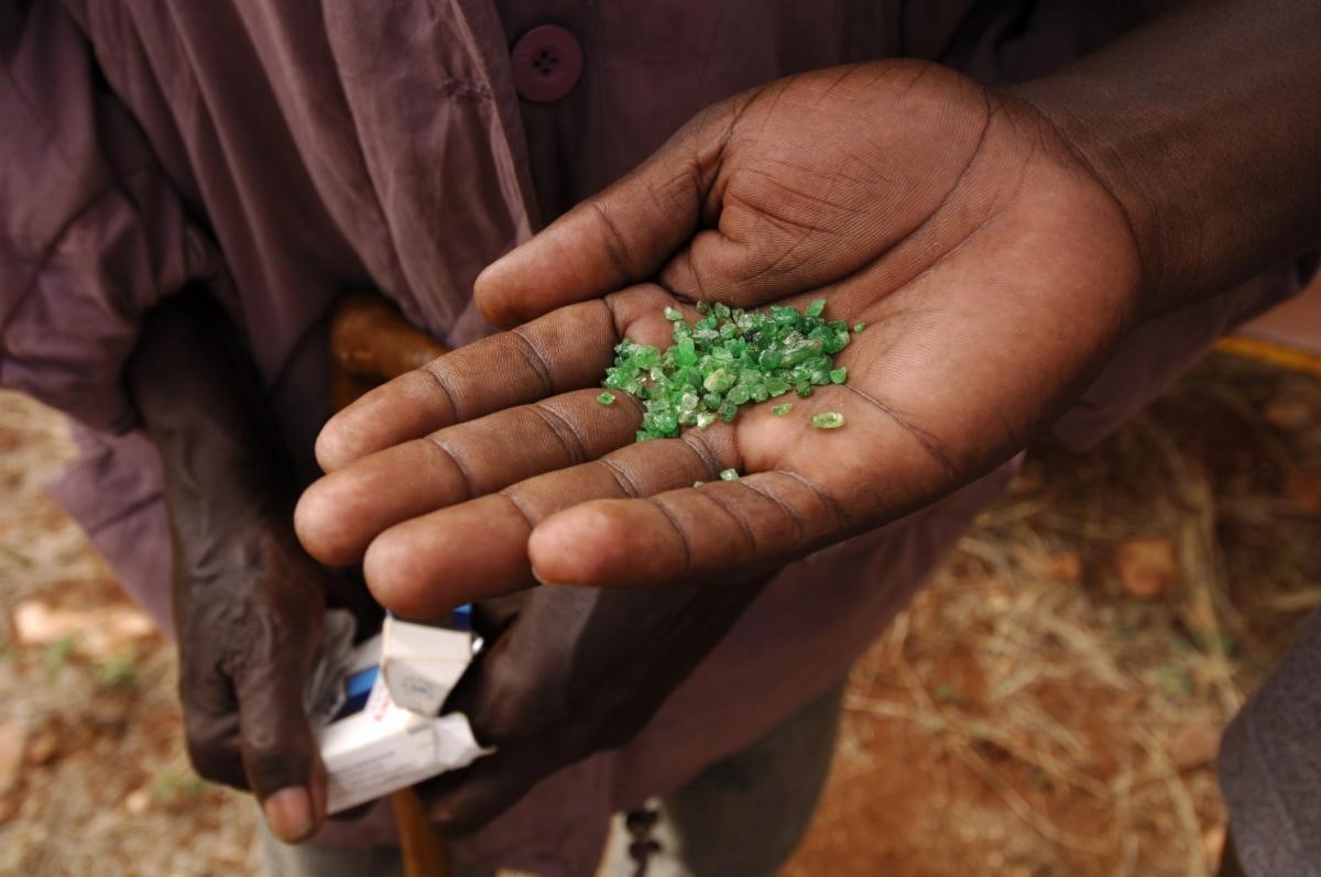 Miner's hand holding tsavorite rough in Kenya. Credit: Photo by Robert Weldon. © GIA