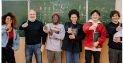 A group of people standing in front of a chalkboardDescription automatically generated