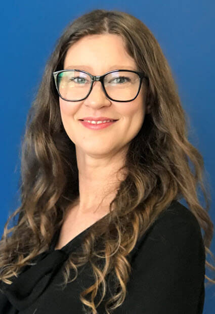 A person with long hair wearing glassesAI-generated content may be incorrect.