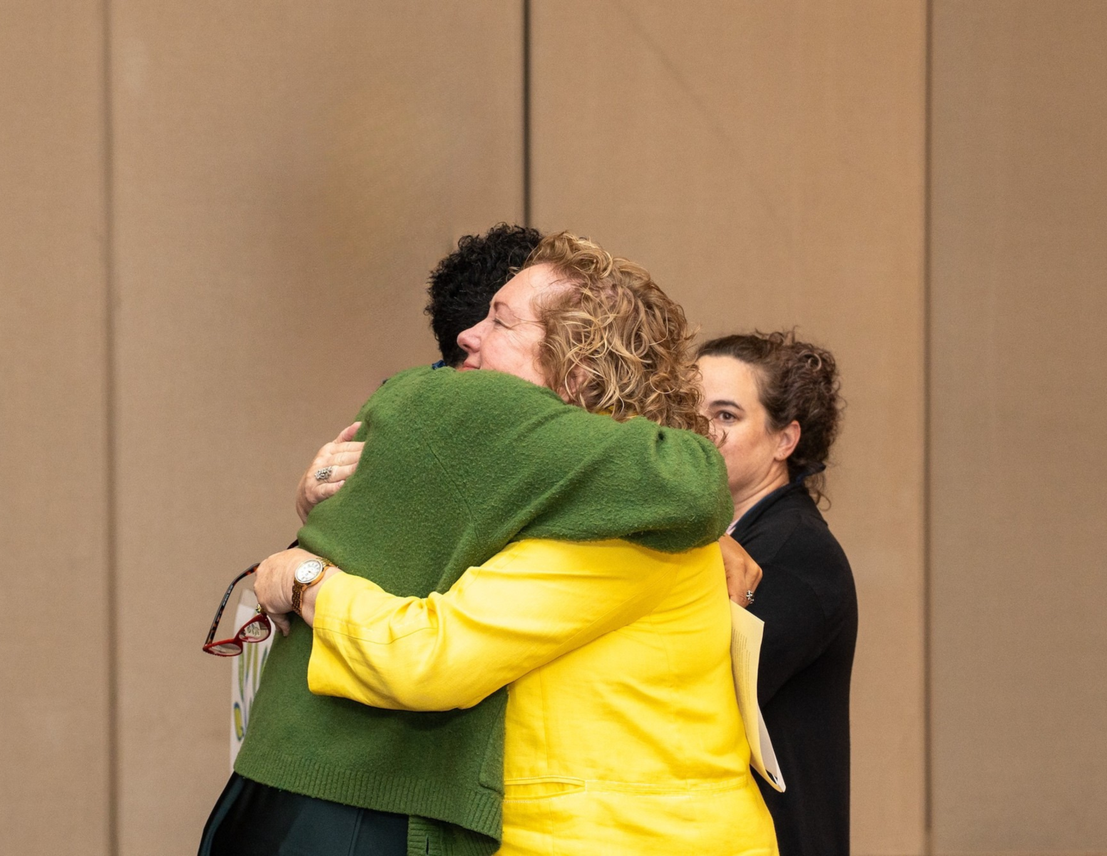 Hannah Oliver Depp hugging Eileen Dengler with Erin Matthews in the background