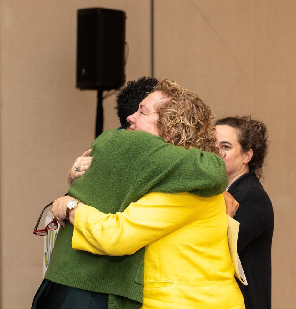Eileen Dengler hugging Hannah Oliver Depp with Erin Matthews in the background