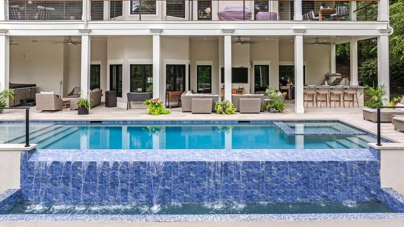 A pool with a large building and a large patioAI-generated content may be incorrect.