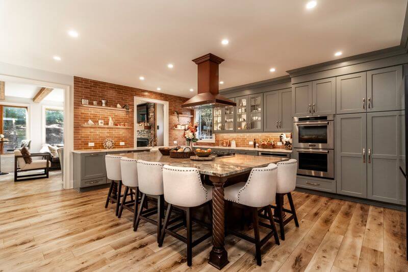 A kitchen with a large island and a brick wallAI-generated content may be incorrect.