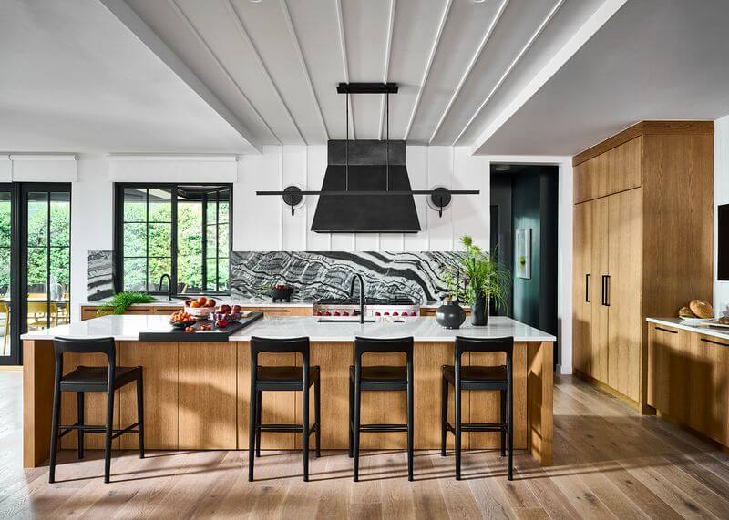 A kitchen with a large island and chairsAI-generated content may be incorrect.