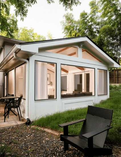 A white house with a chair and a lawnAI-generated content may be incorrect.