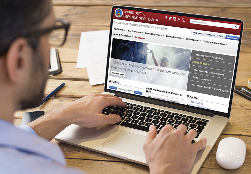 man visiting OSHA website on laptop