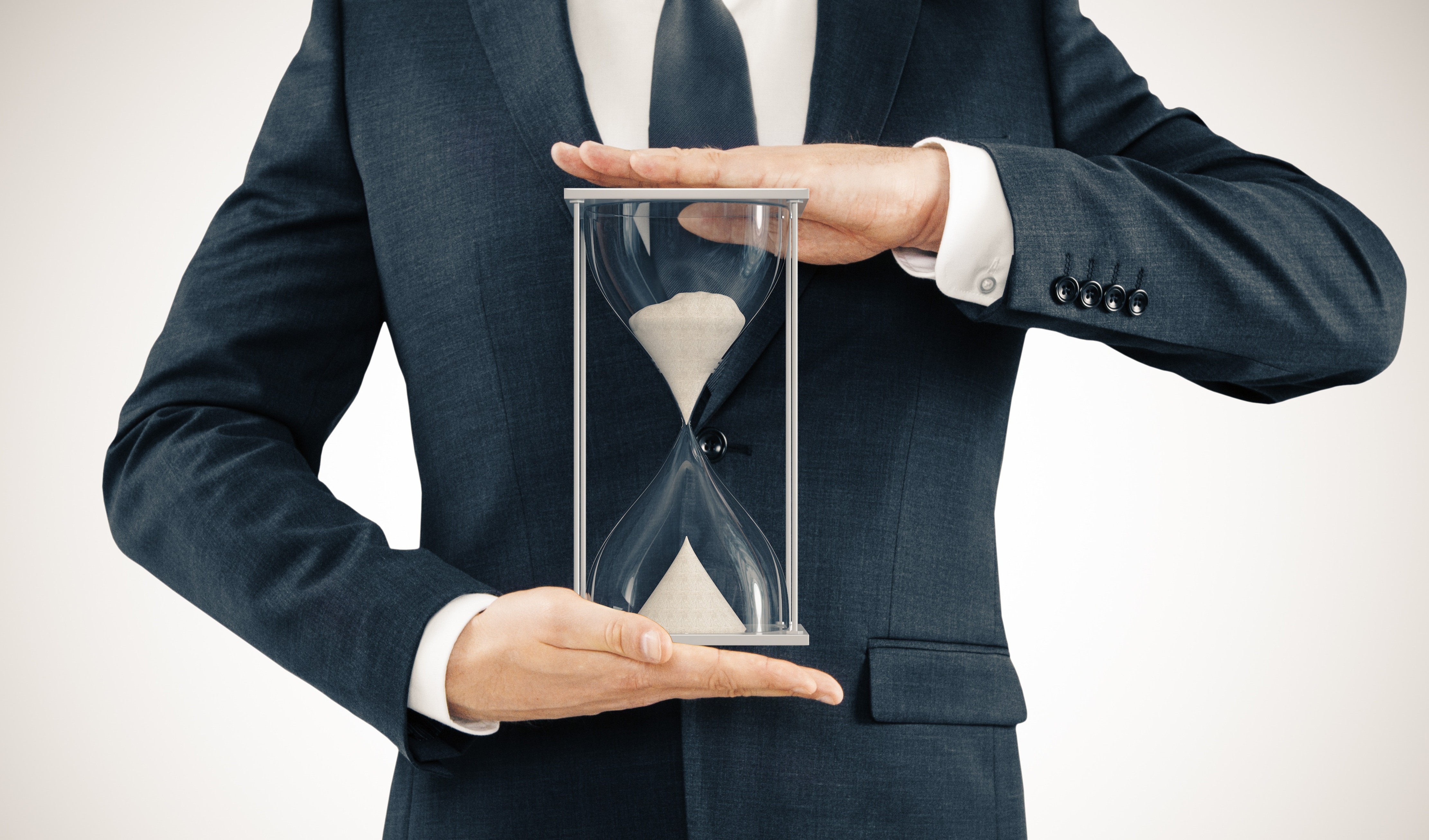 man in suit holding hourglass 