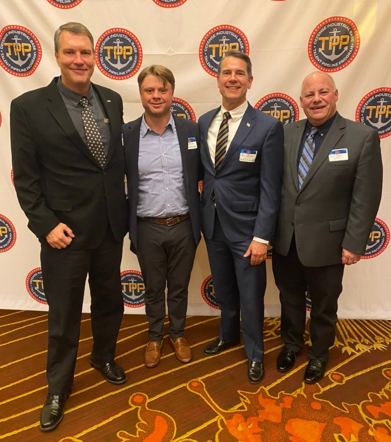 Jerrod Weaver (NFFS), Bill Padnos (NFFS), with Navy representatives in front of TPP backdrop