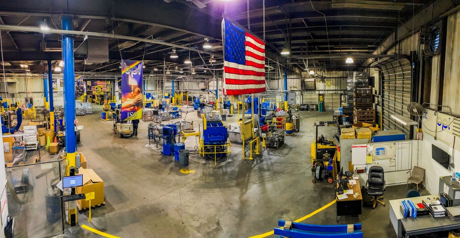 Wide view of Batesville Products manufacturing floor with an American flag overhead