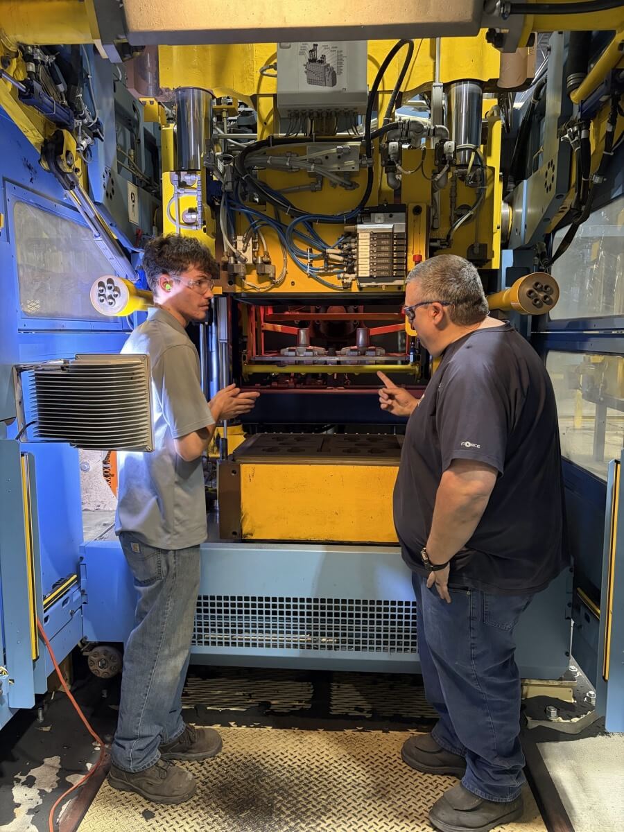 Nathan Alfieri discussing foundry equipment with a colleague at Erie Bronze & Aluminum