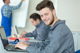 young man wearing work uniform and working at a computer 