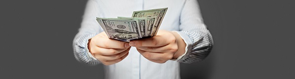 Man holding out a handful of dollar bills